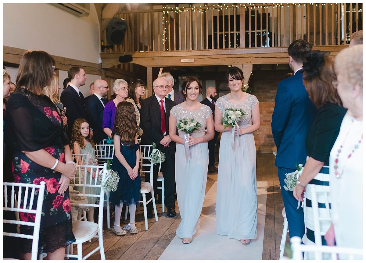 Bridesmaids walking down aisle in grey maxi dresses