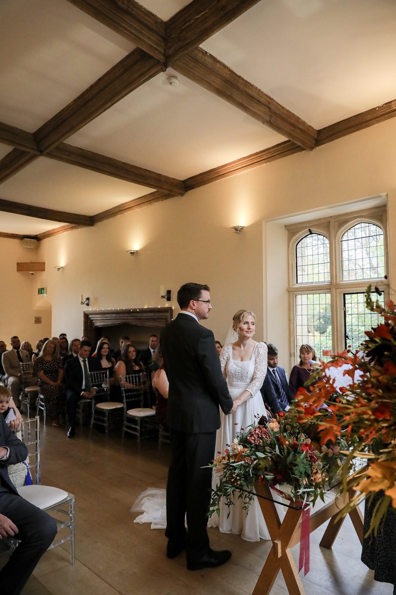 Wedding ceremony in the historic Abbot's Hall beneath carved oak beams at Notley Abbey, Buckinghamshire
