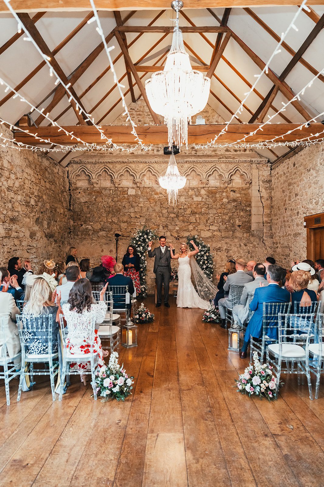 Guests watch a wedding ceremony in the Monks' Refectory stone barn at Notley Abbey, Buckinghamshire