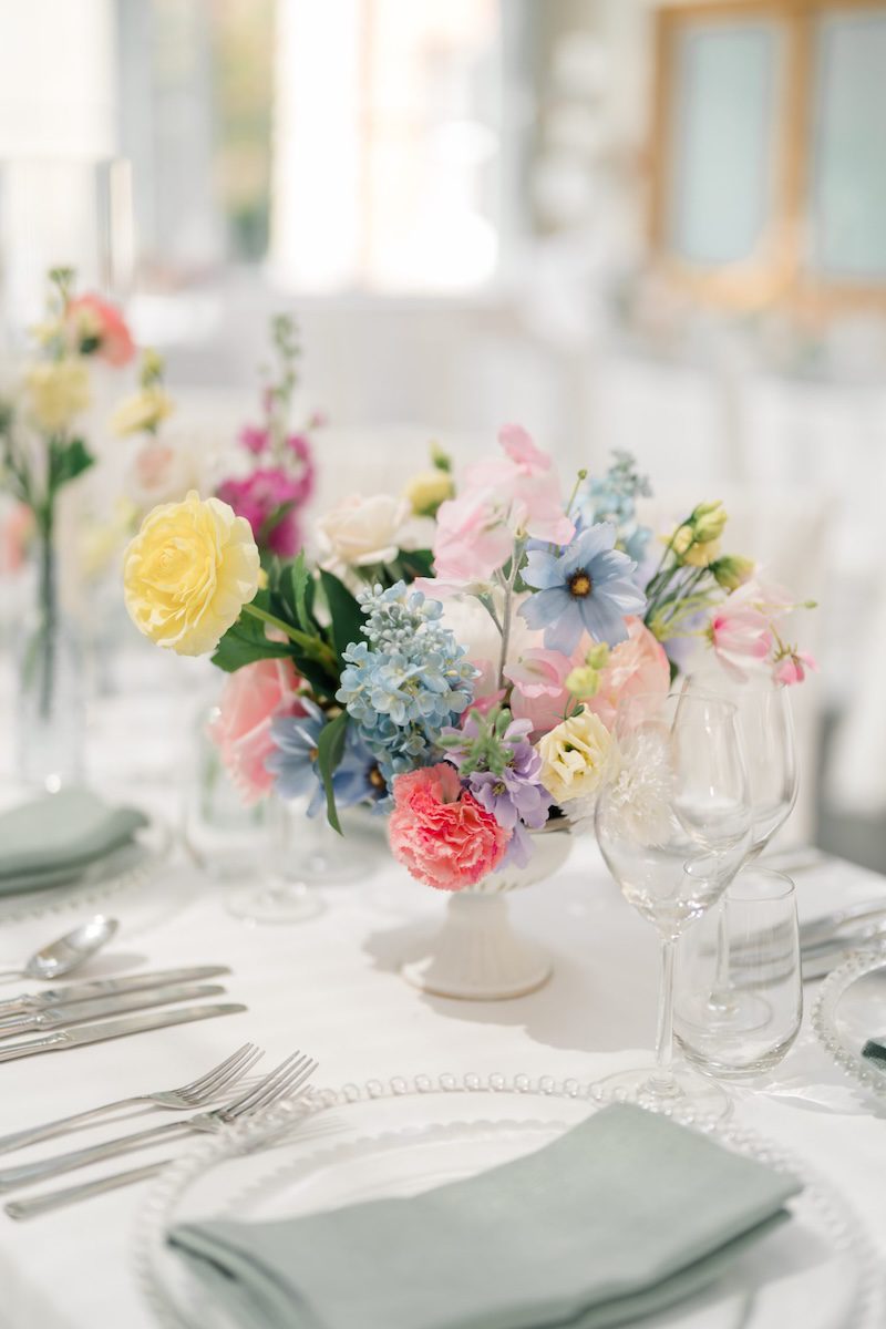 Pastel wedding centrepiece of roses and hydrangea with sage napkins, styled by florist CK Wedding Flowers